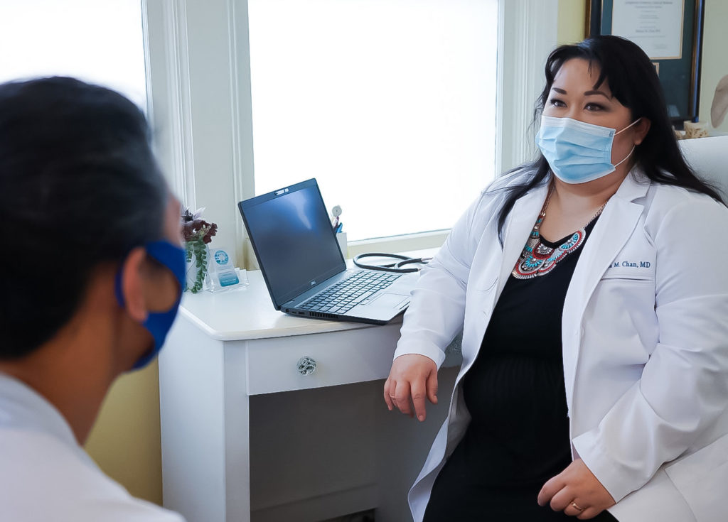 Dr. Chan discussing treatment options with a patient in the Salt Lake City Lotus Health office